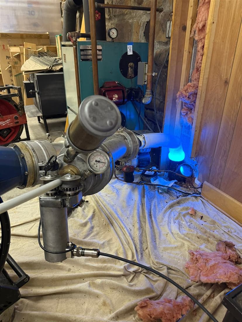 LiningWorks inversion equipment set up in a basement to line a sewer pipe