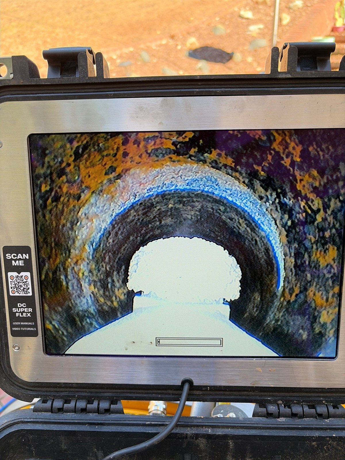 Sewer camera inspection screen showing rust colored corrosion and scale on the inside wall of a sewer pipe