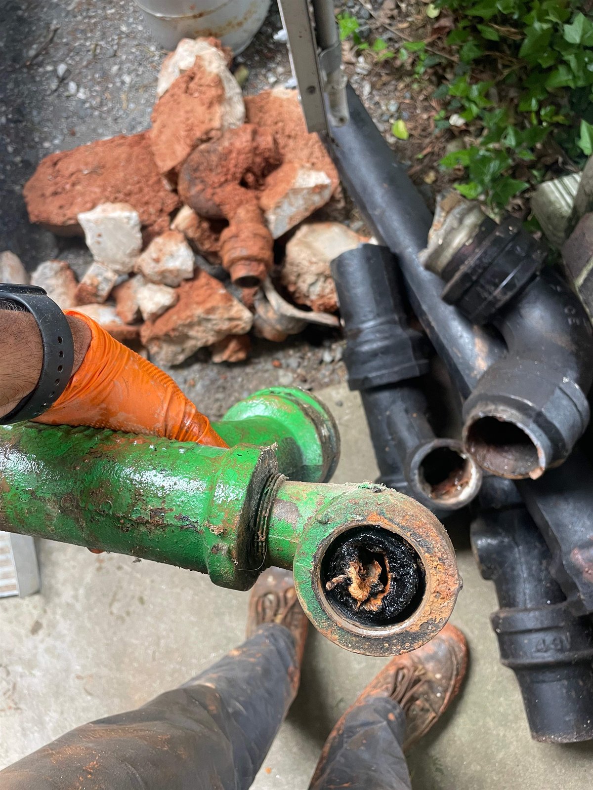 LiningWorks technician inspecting a heavily clogged cast iron sewer pipe in Charlotte.
