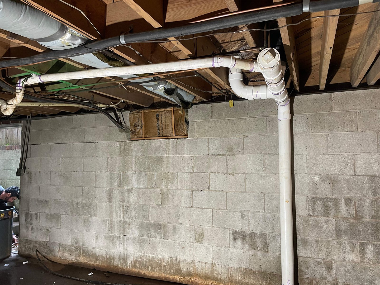 LiningWorks crew working on drain lines in a Winston-Salem basement, where vertical stacks meet the building drain.