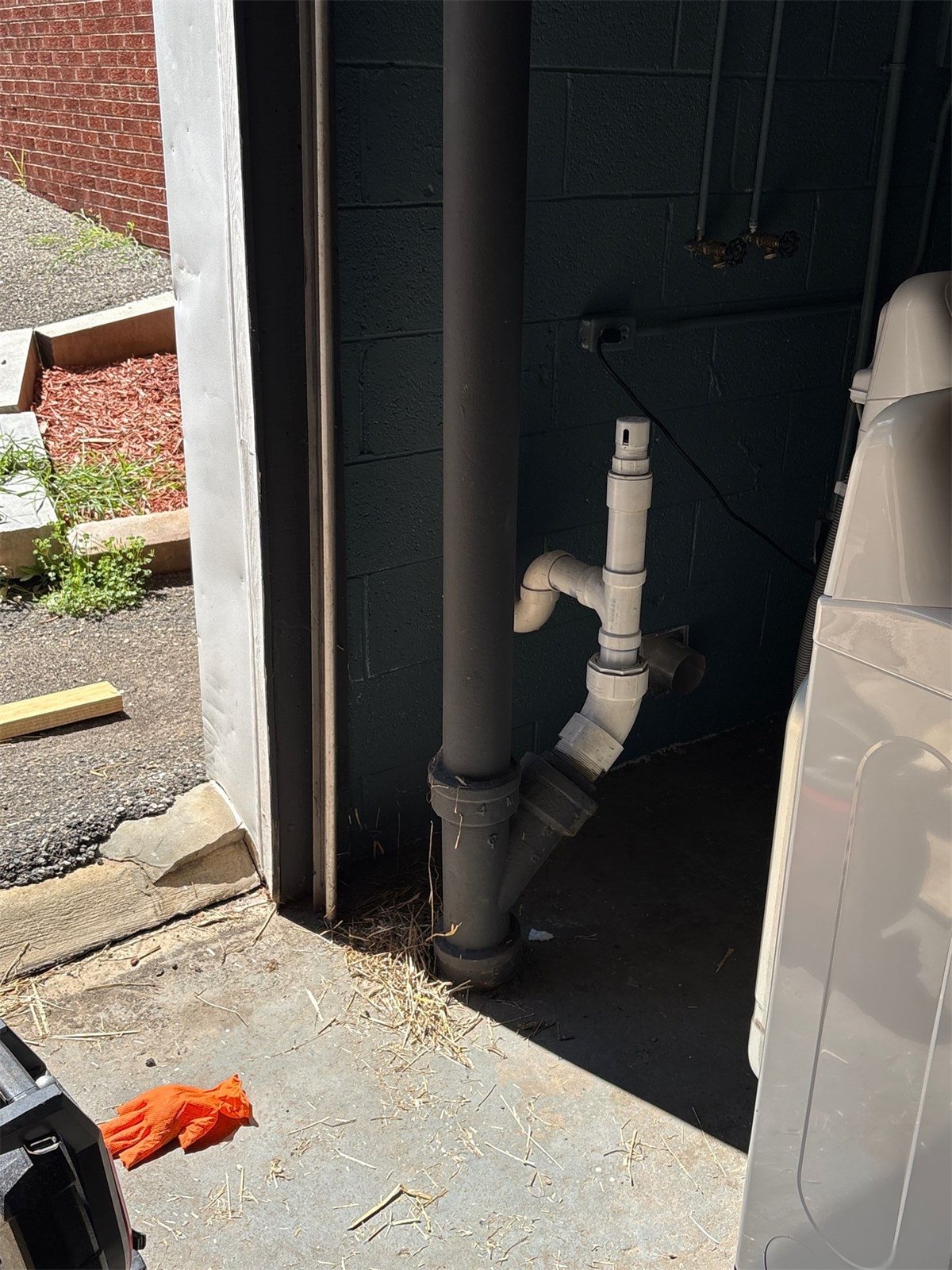 Cast iron and PVC drain connections at a laundry area, the kind of interior stack work LiningWorks handles.