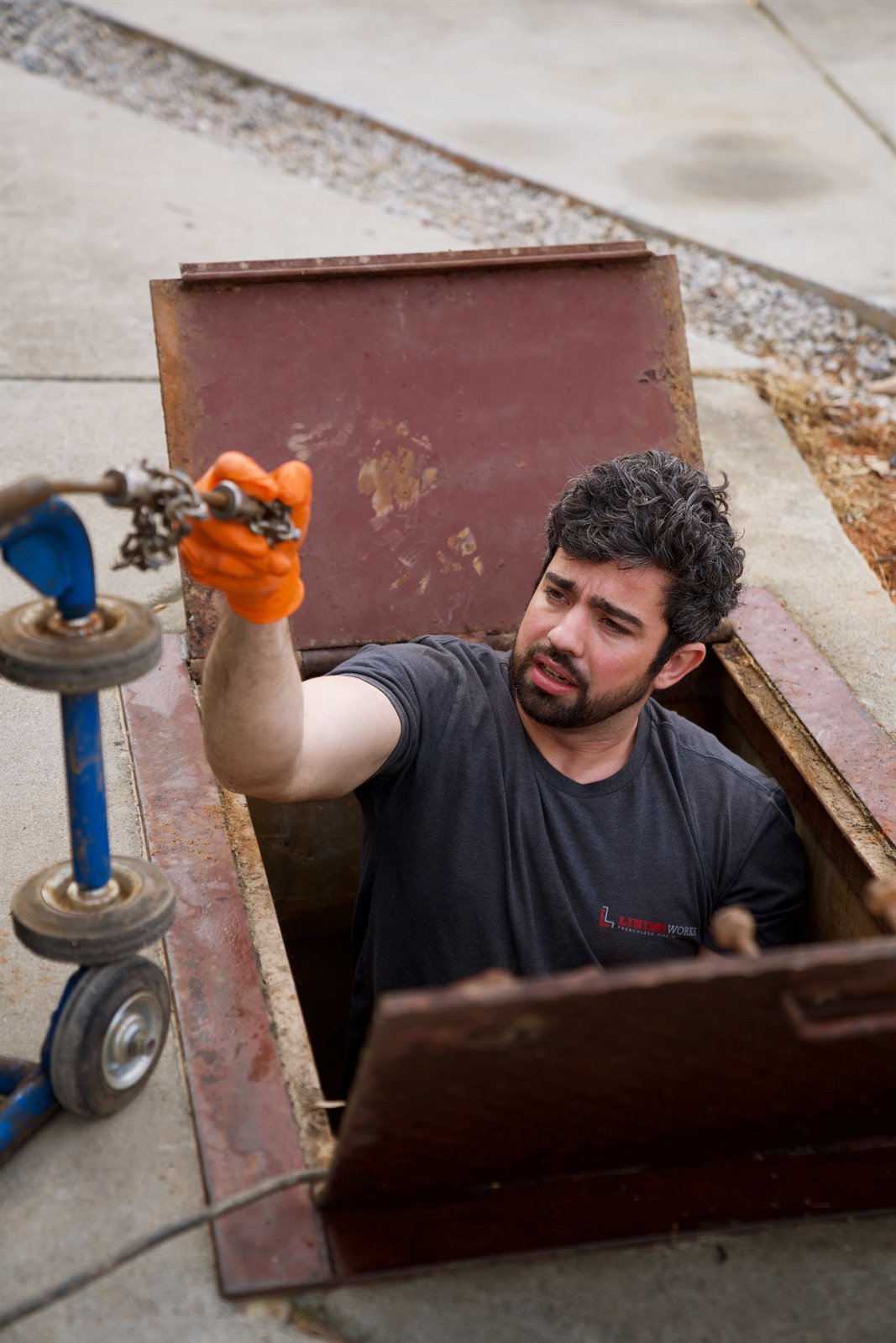 LiningWorks technician working from a storm drain access vault with a chain flail root cutter head.
