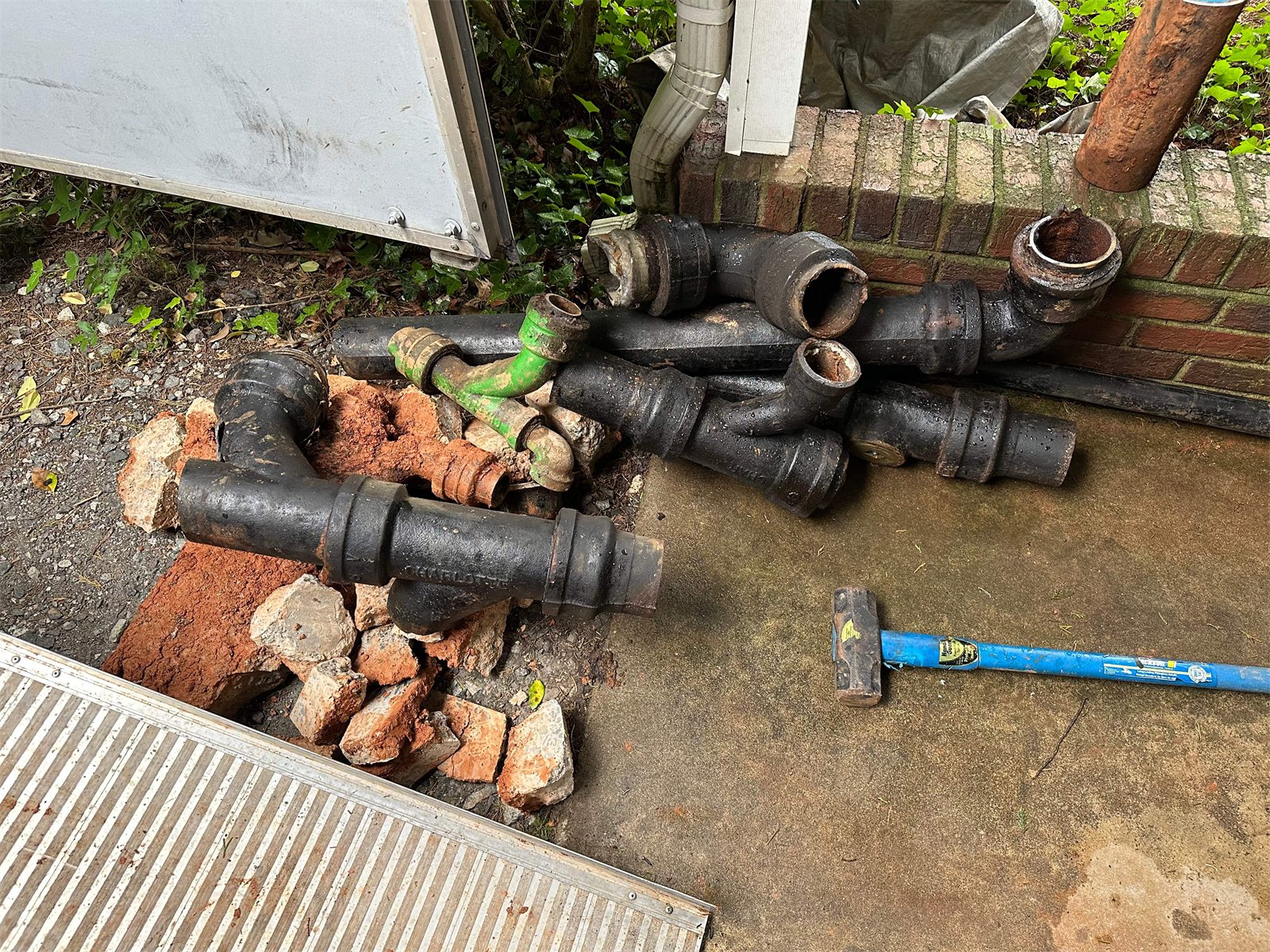 LiningWorks crew with old cast iron pipes removed during a repair.