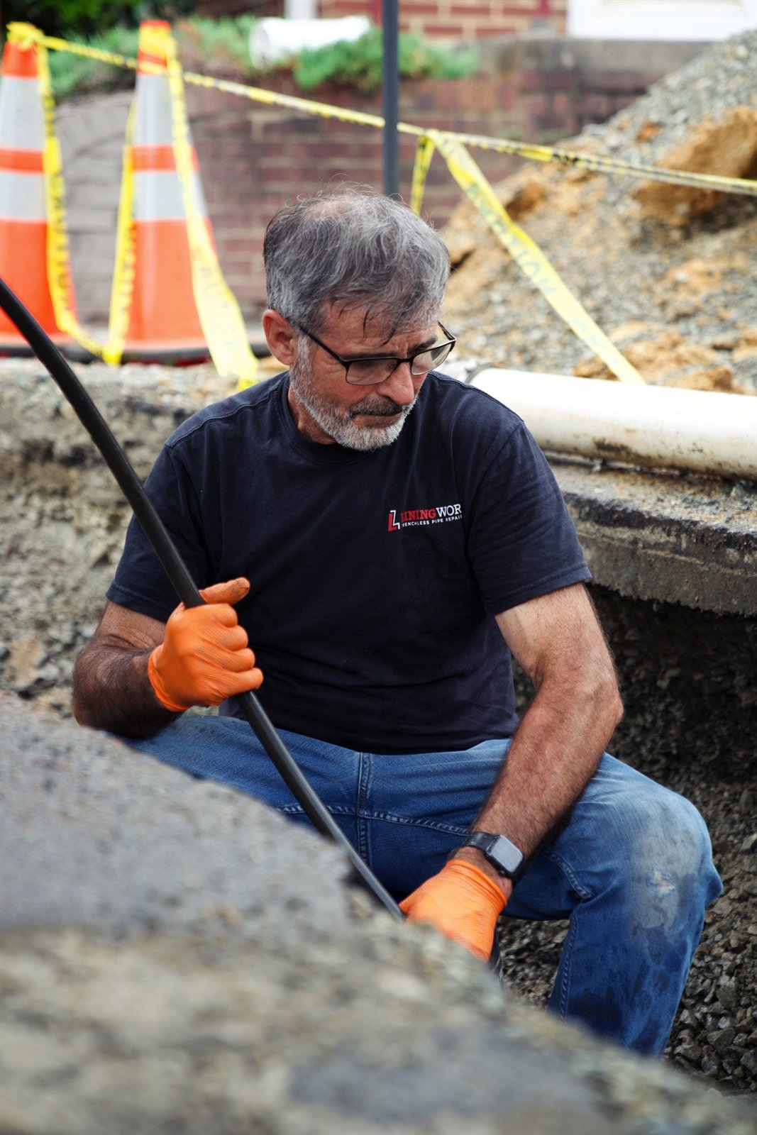 LiningWorks technician at an excavated trench preparing the host pipe for CIPP lining.