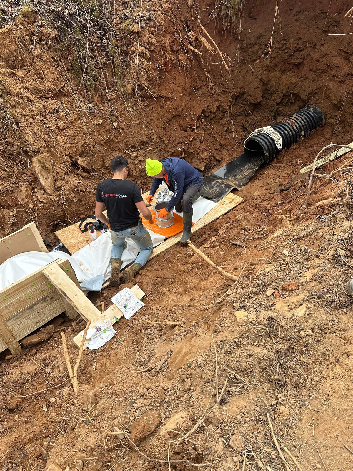 LiningWorks crew preparing a CIPP liner for installation in a corrugated storm drain pipe.