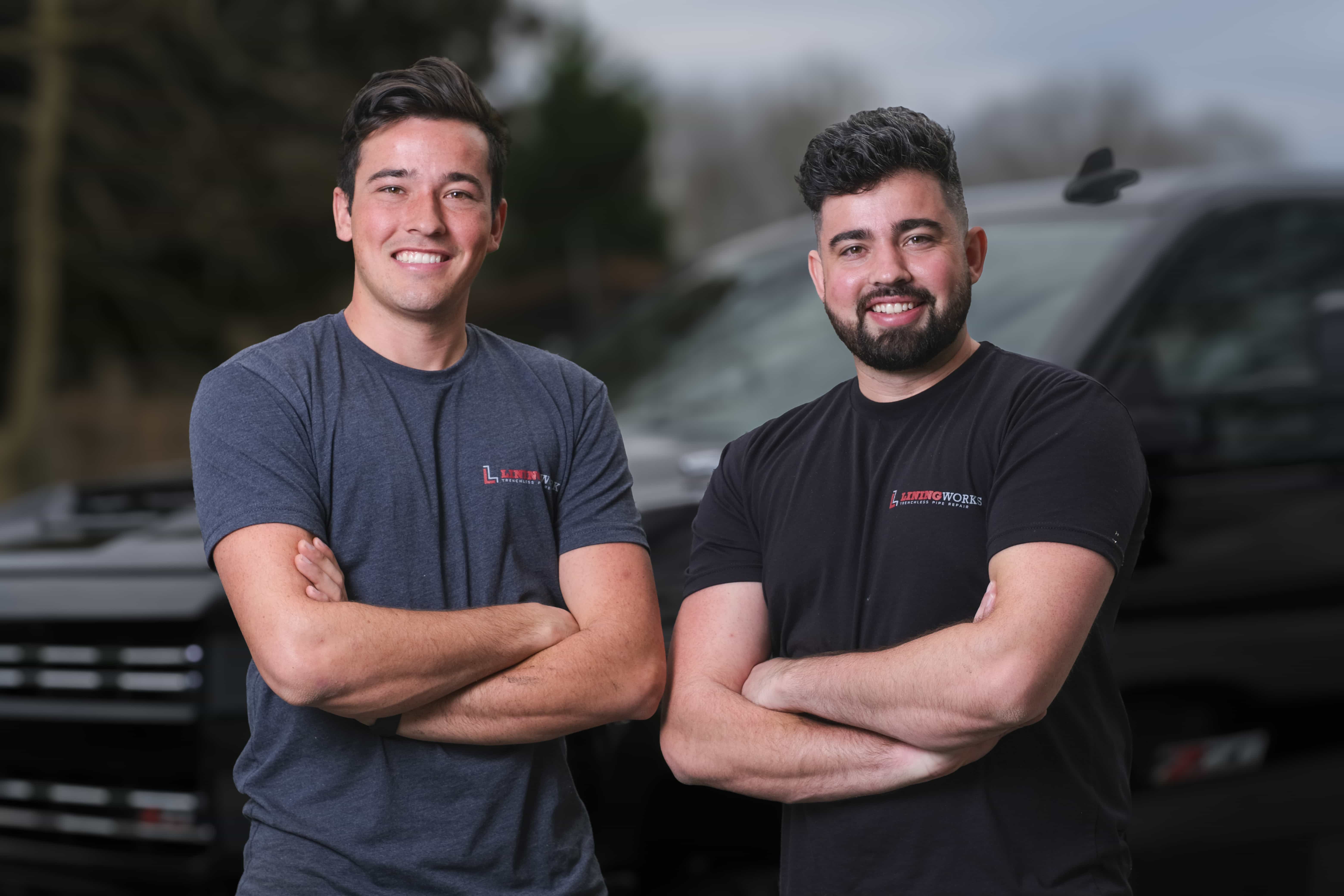 The LiningWorks brothers in front of two service trucks.