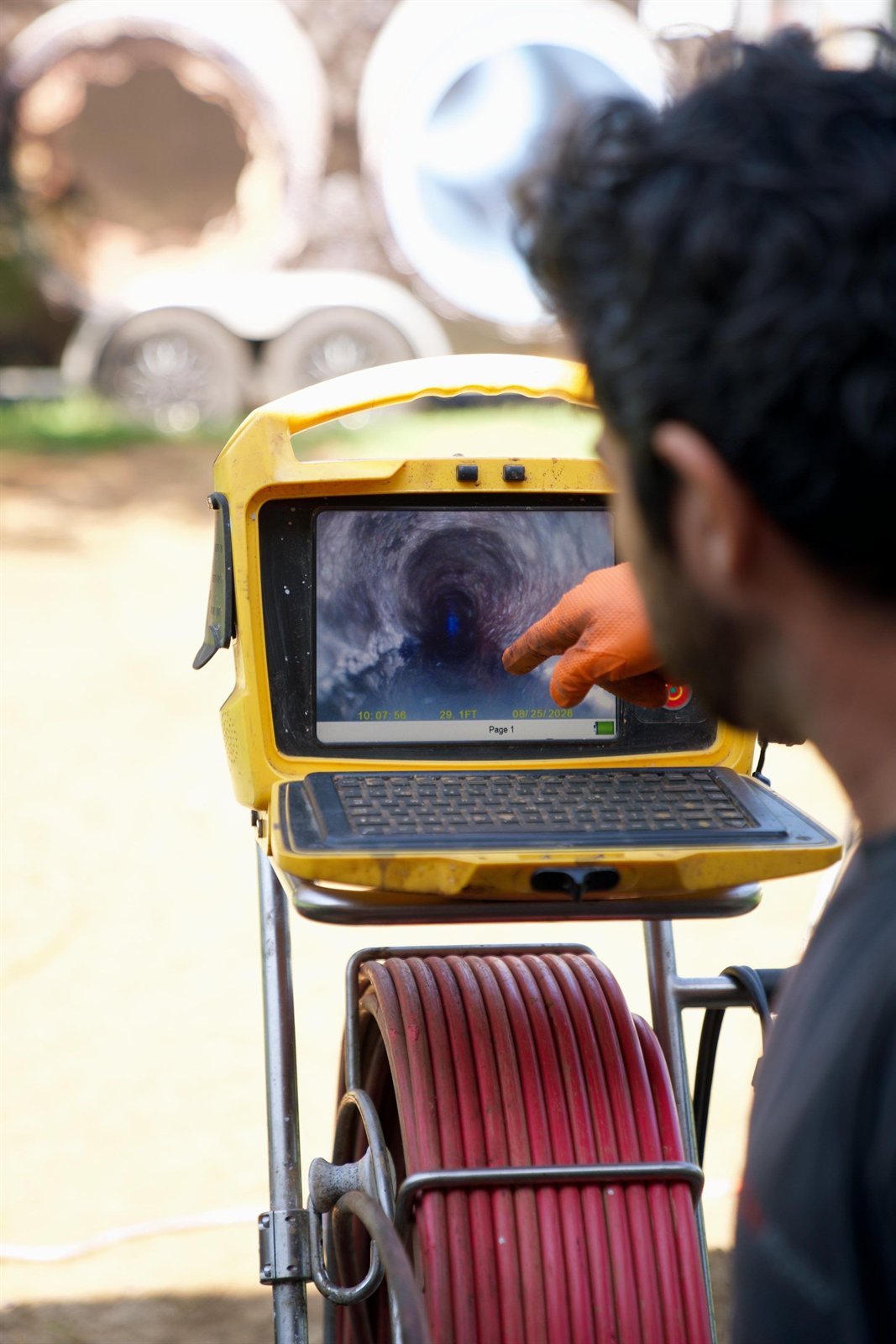 LiningWorks technician running a digital pipe evaluation to trace where sewer odors are escaping.