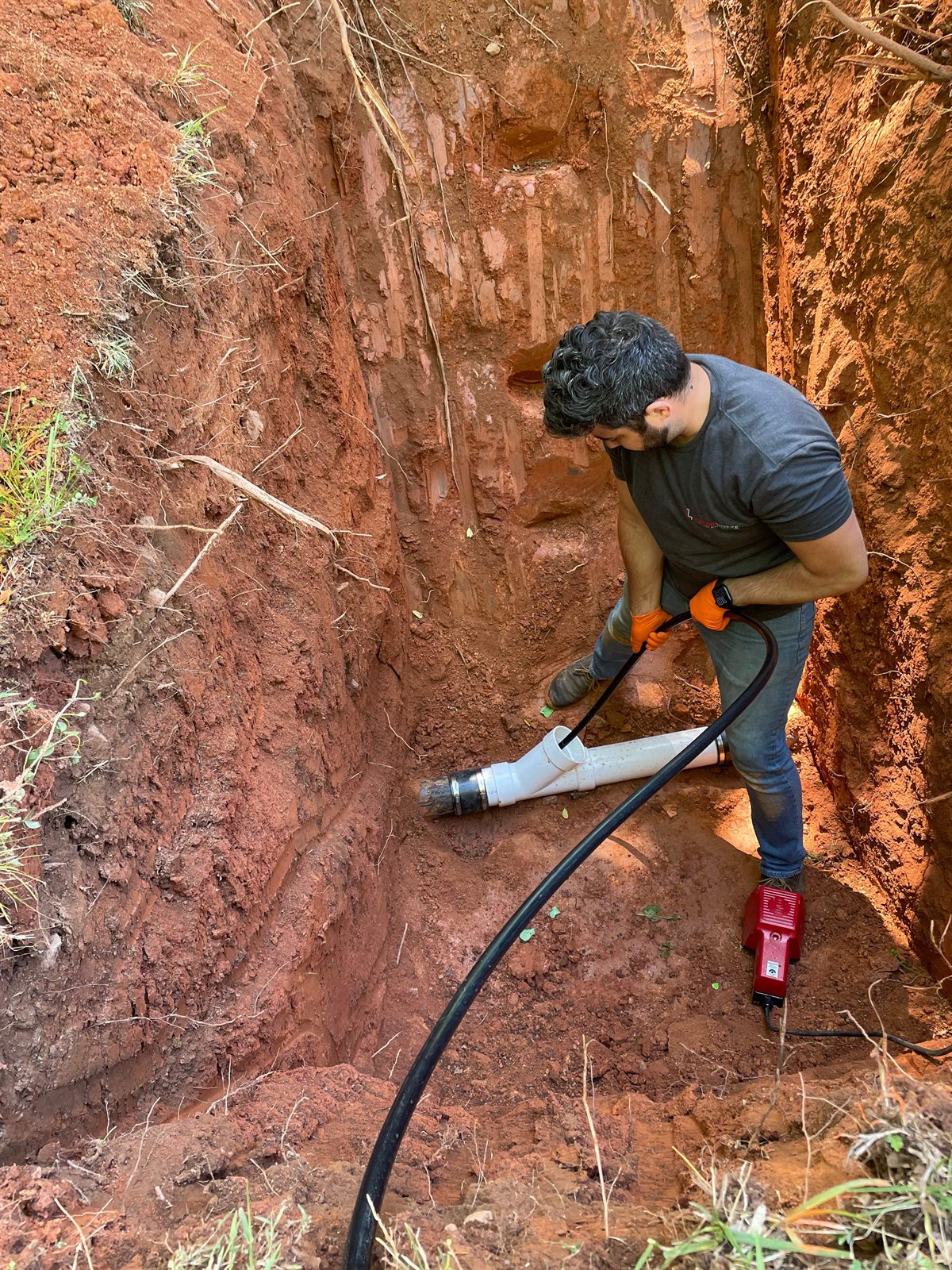 LiningWorks technician working on a sewer line in an excavated trench.