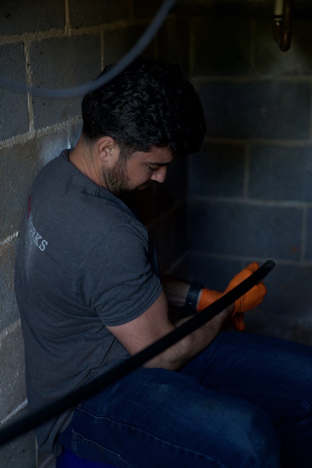 LiningWorks technician running a sewer camera inspection at an indoor access point.