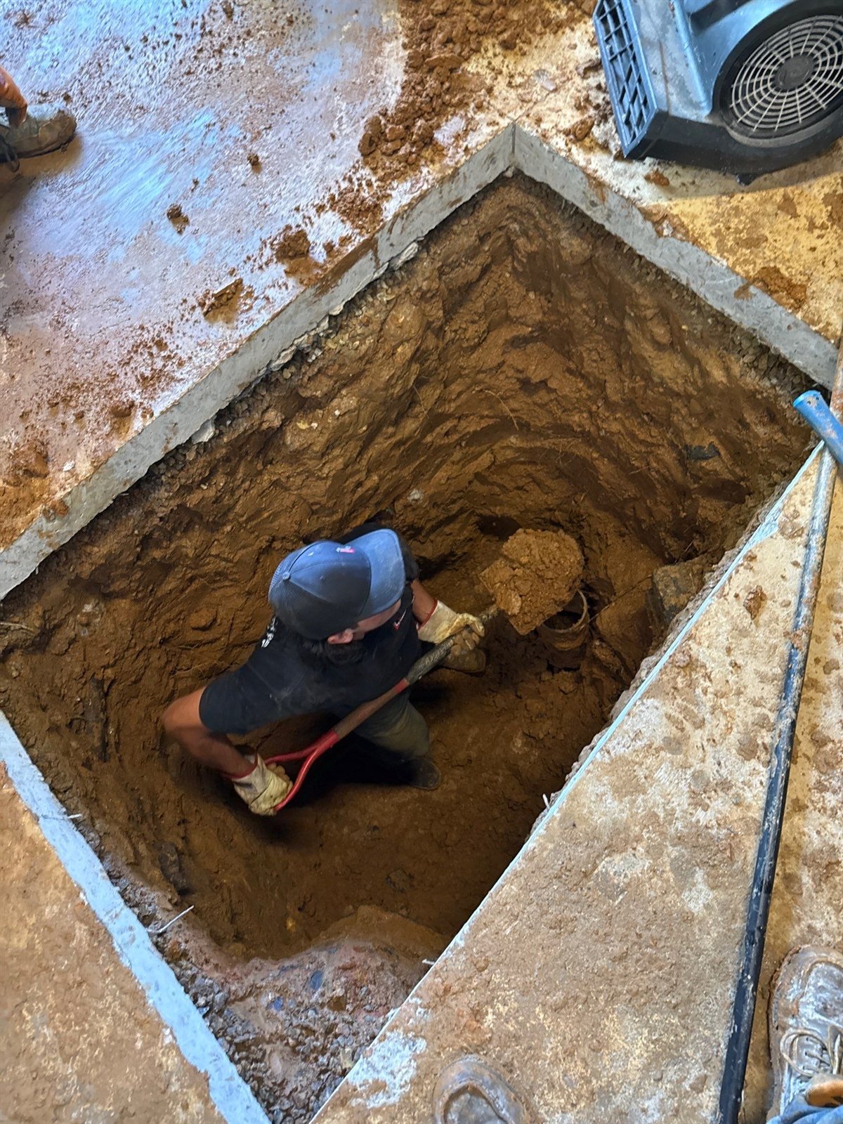 LiningWorks technician working at an excavated access point on a sewer line.